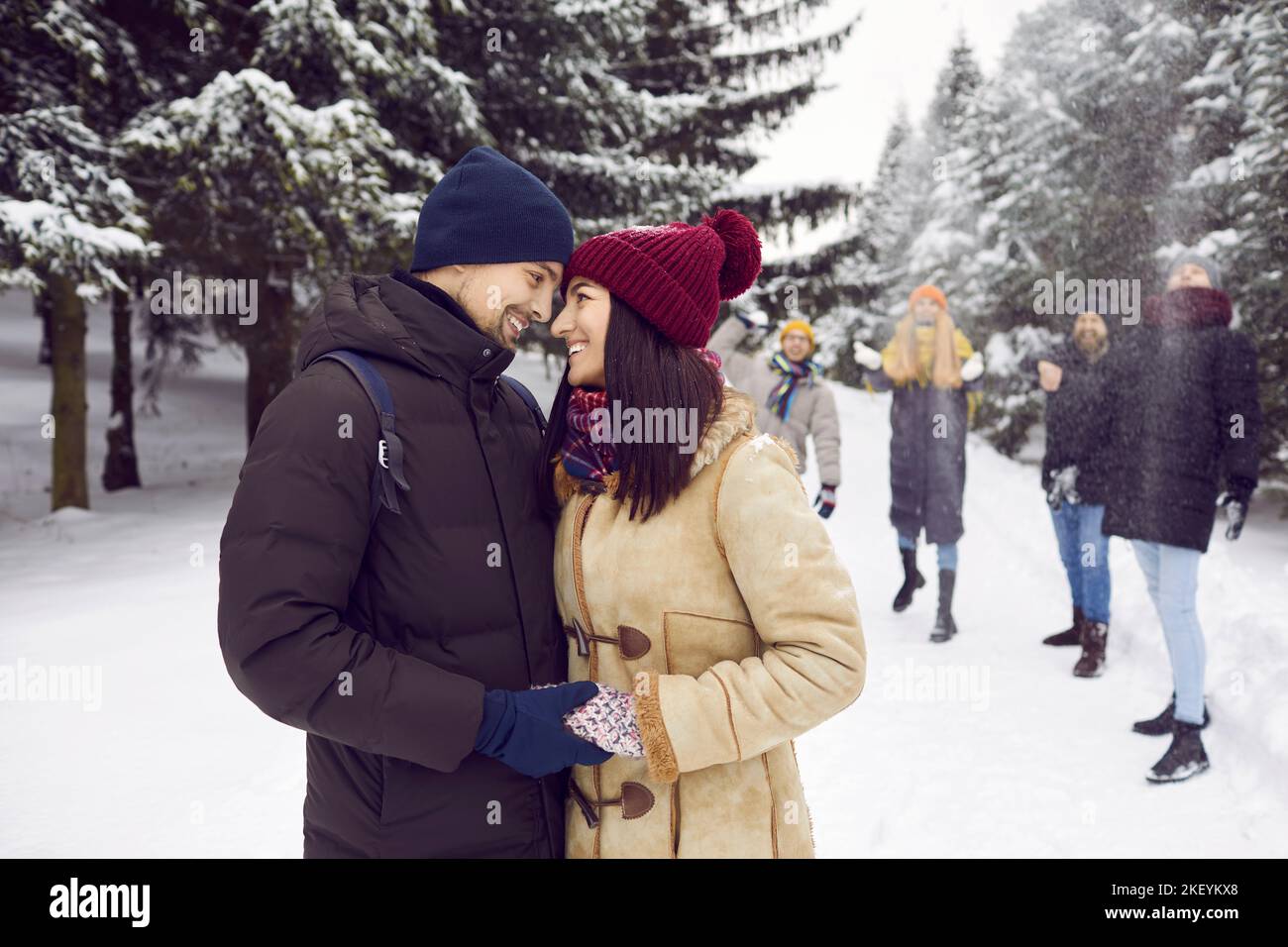 Happy couple in love spending wonderful day in winter forest in company ...