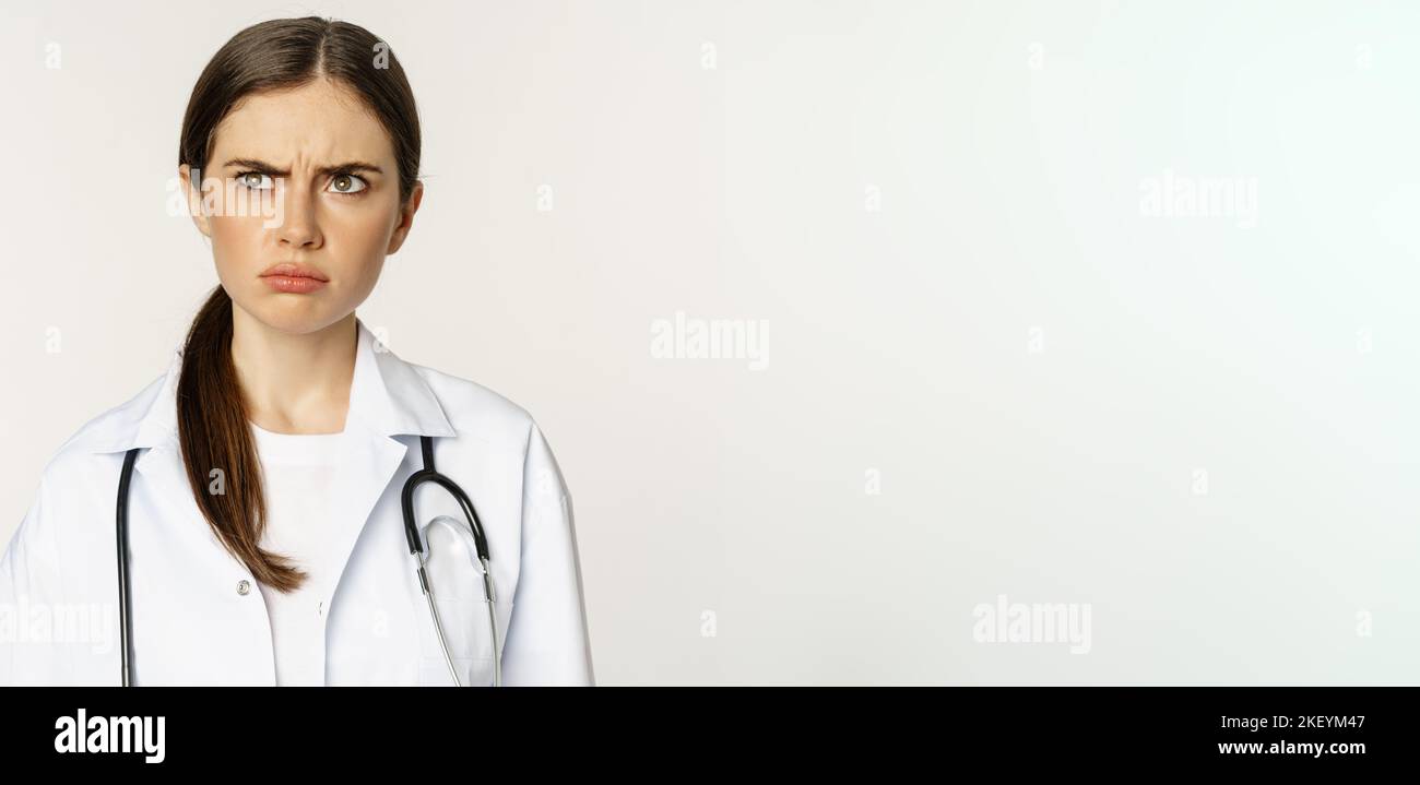Angry and upset young woman doctor, female healthcare worker sulking ...
