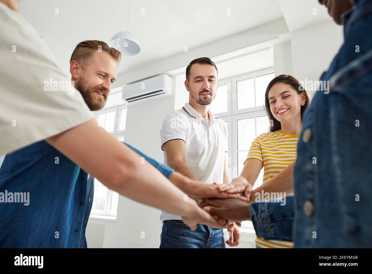 Team of happy people joining their hands to show concept of teamwork and success Stock Photo