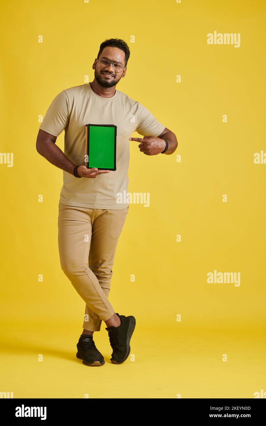 Happy programmer holding tablet computer with green screen, content production concept Stock Photo