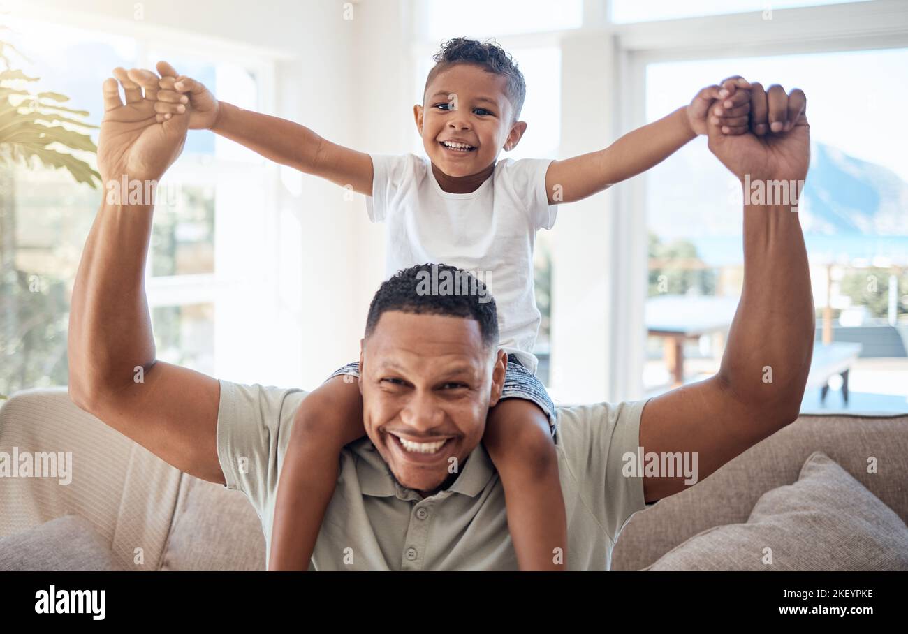 Portrait, father and son on shoulder, smile and happy being loving, bonding and playful together in lounge. Love, black dad and boy child with Stock Photo