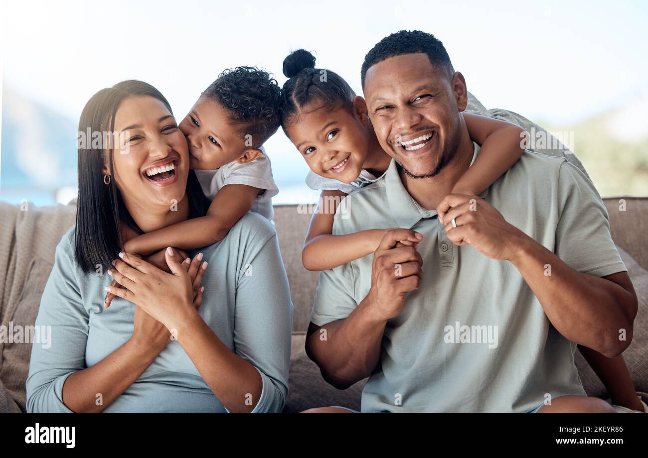 Happy family, mother and father with children in a portrait in a sofa bonding hugging and laughing together. Mom, dad and fun Mexican kids playing Stock Photo