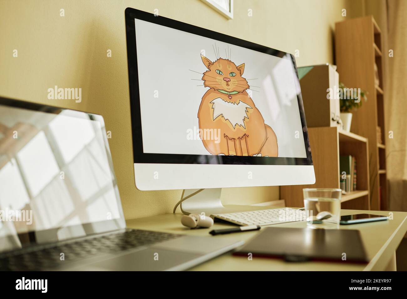 Focus on computer screen with graphic picture of fat and fluffy ginger cat on white background drawn by modern digital artist Stock Photo