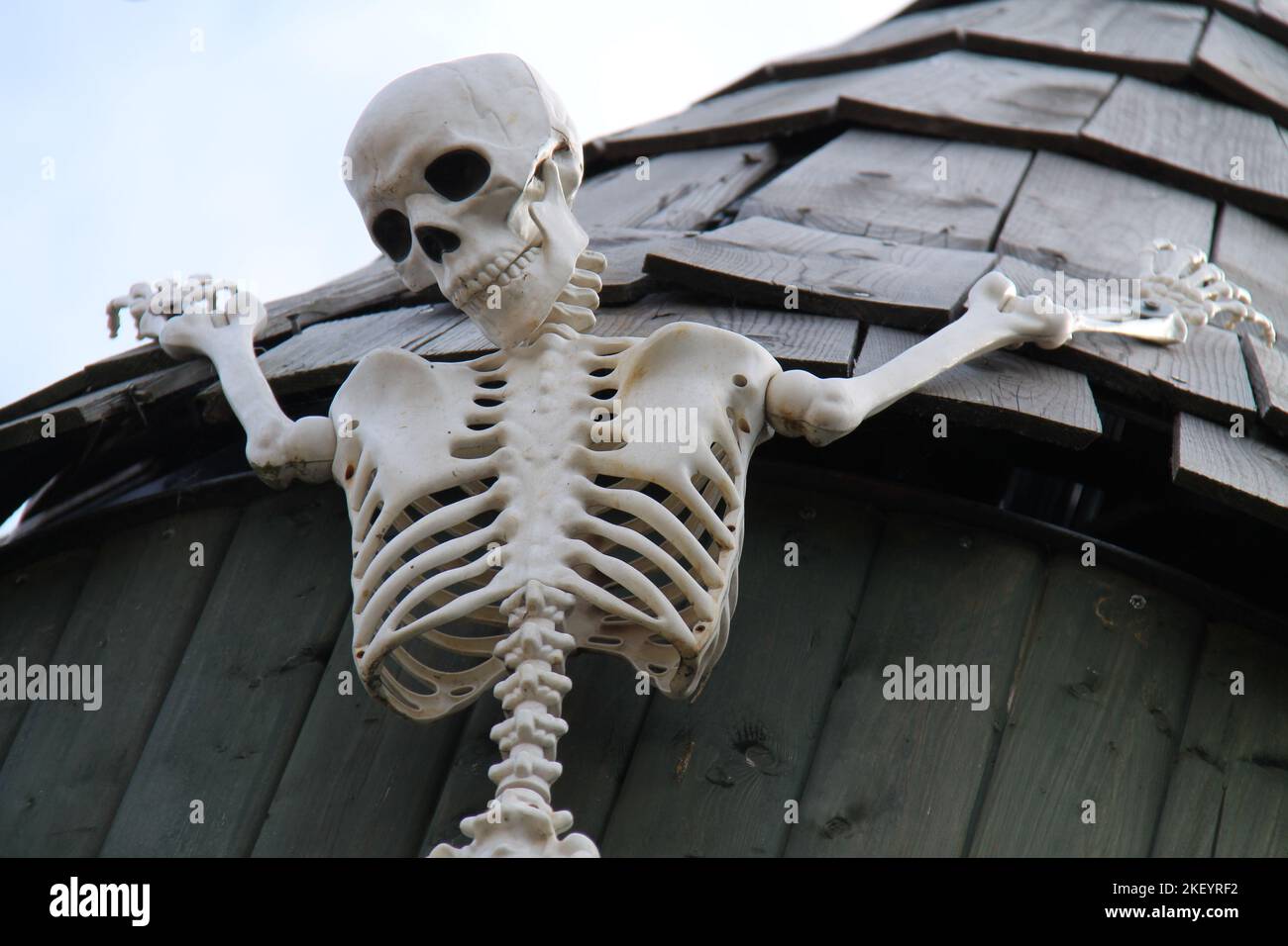 A Skeleton Figure Hanging from a Building Roof. Stock Photo