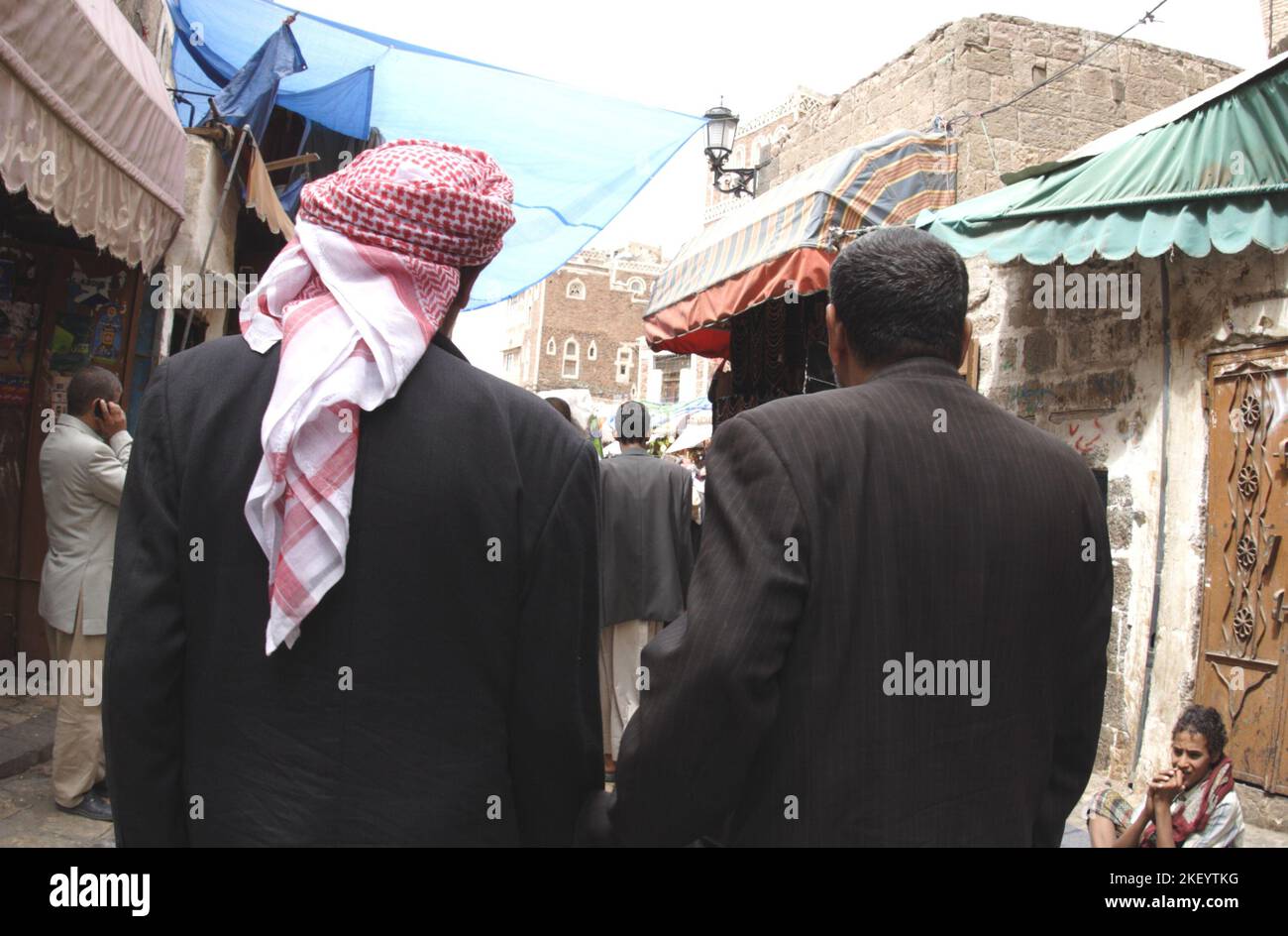 Two Yemeni men walking through a narrow alley of the old city bazaar, Sana’a, Yemen Stock Photo
