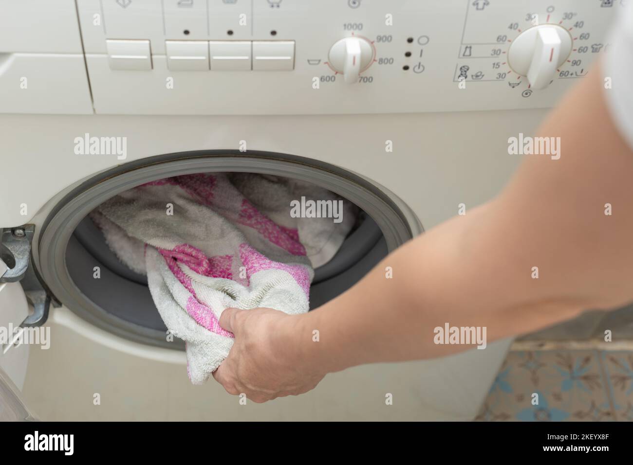 man taking clothes out of the washing machine. hand takes out washed