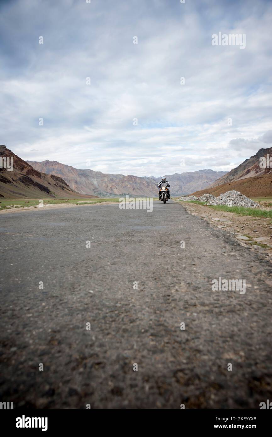 Man driving a bike on KeylongLeh Road in the Himalayas, Himachal