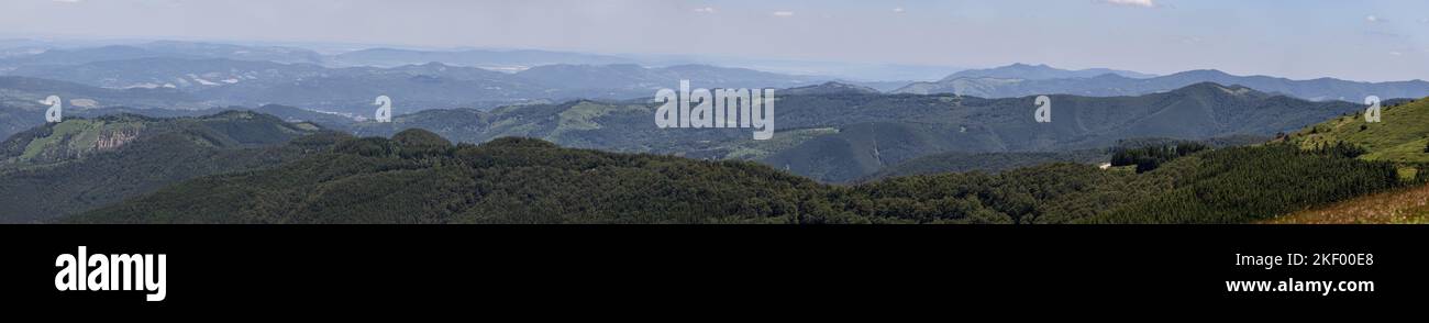 Maxi panoramic photo of the endless Balkans, overgrown with forests with valleys and meadows in a summer haze, Bulgaria Stock Photo