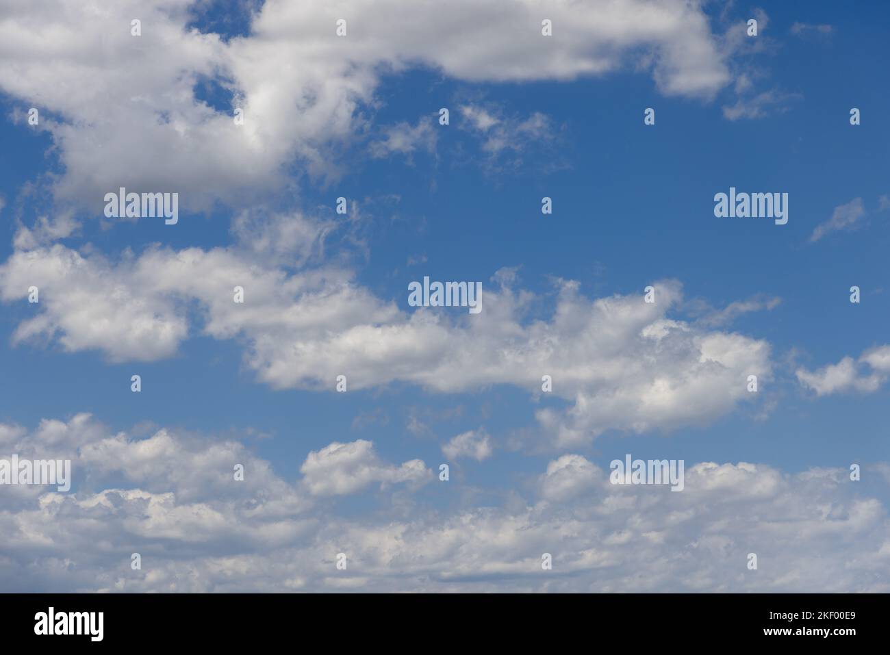 Summer midday pale blue sky with white fluffy lightest clouds torn evenly over it Stock Photo
