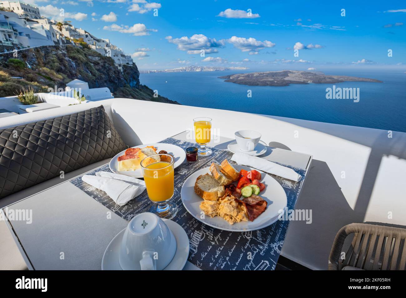 Breakfast time in Santorini in hotel. Luxury mood with fresh omelet and fruits with juice over sea view. Luxurious summer traveling holiday background Stock Photo
