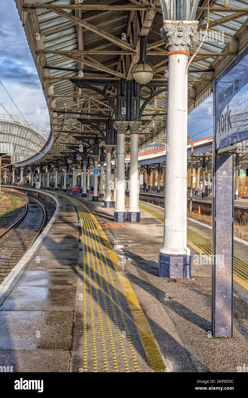 A railway station after a rainfall. Water glistens on the platform and ...