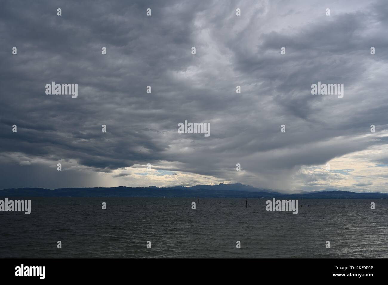 Heavy dark blue and gray rain clouds over Lake Constance observed from German town Friedrichshafen. Stock Photo