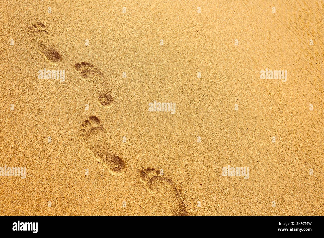 Beach, wave and footprints at sunset time Stock Photo