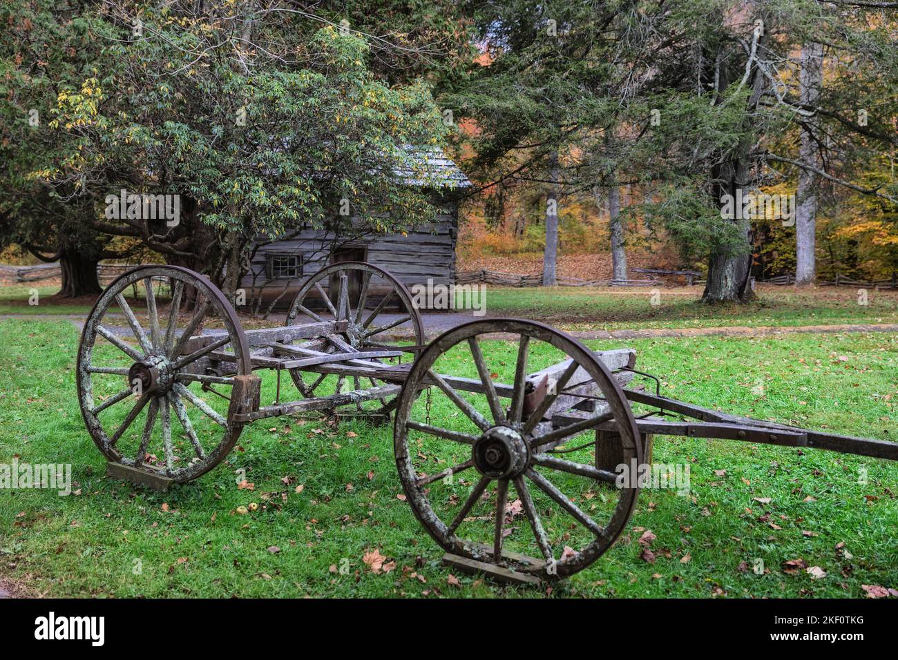 Vesta, Virginia, USA - October 15th, 2022:  Mathew's Cabin in the background with an old wagon frame in the fore ground at Mabry Grist Mill along the Stock Photo
