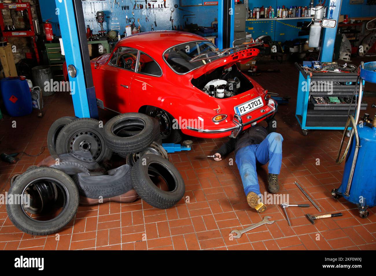 From the COLOR BODIES calendar 2023 - camouflage art bodypainting: car tire bodypainting with the models Sugarbabe and Kristina and the mechanic Günther in the car workshop Car-Circle in Unsen. A project by the photographer Tschiponnique Skupin and the bodypainter Jörg Düsterwald. Stock Photo