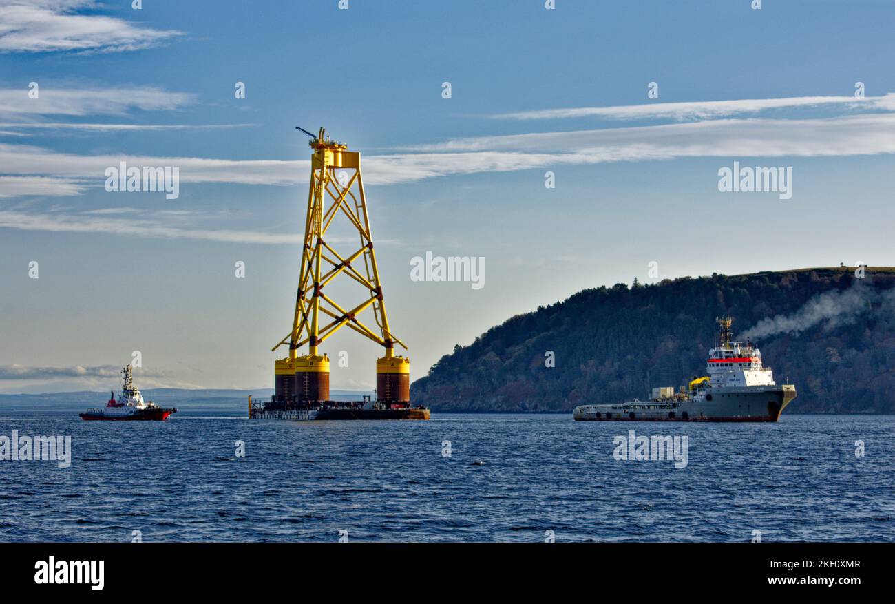 Cromarty Firth Nigg Scotland  two tugs towing the yellow jacket base of an offshore wind turbine into harbour Stock Photo