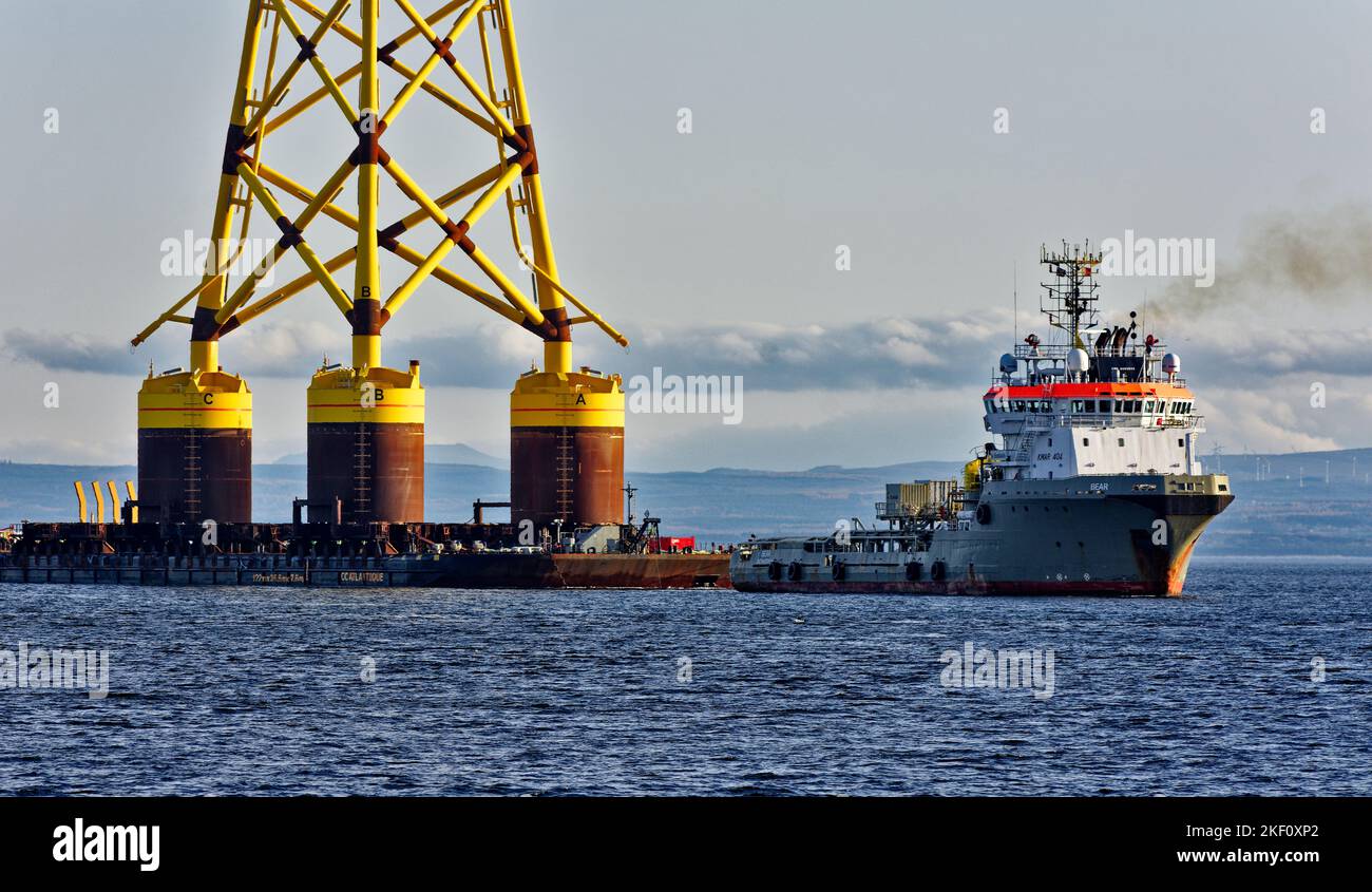 Cromarty Firth Nigg Scotland vessel Bear towing the yellow jacket base of an offshore wind turbine into the harbour Stock Photo