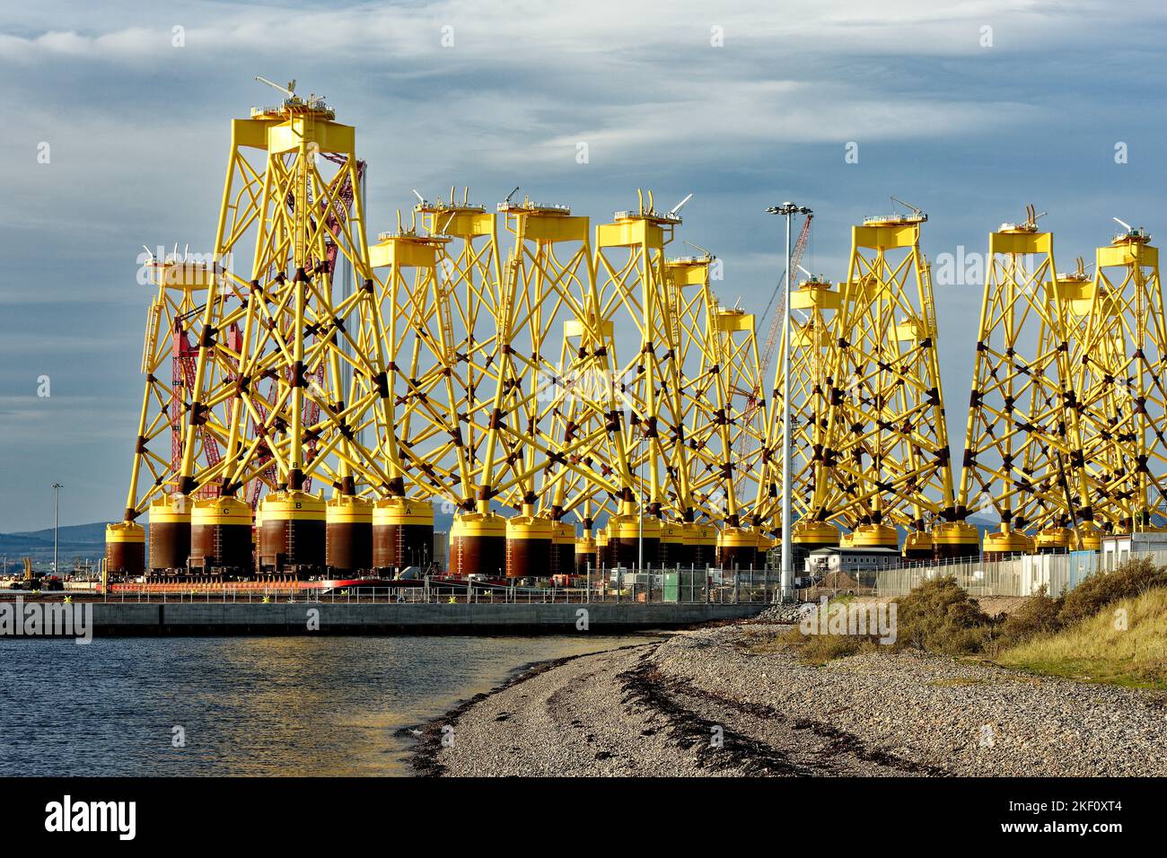 Cromarty Firth Scotland Nigg port rows of new yellow bases or yellow jackets for off shore wind turbines Stock Photo