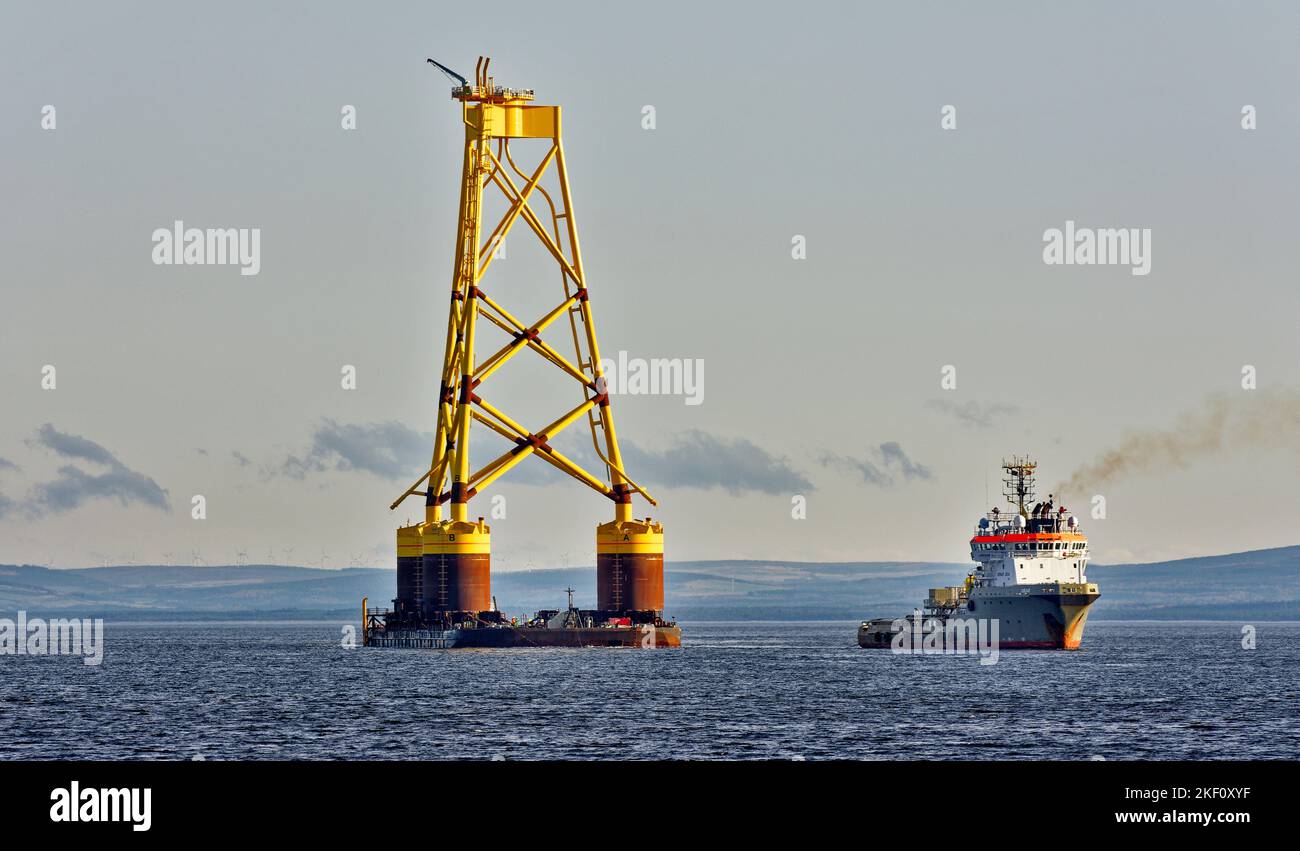 Cromarty Firth Scotland Nigg vessel towing the yellow jacket base of an offshore wind turbine into the harbour Stock Photo