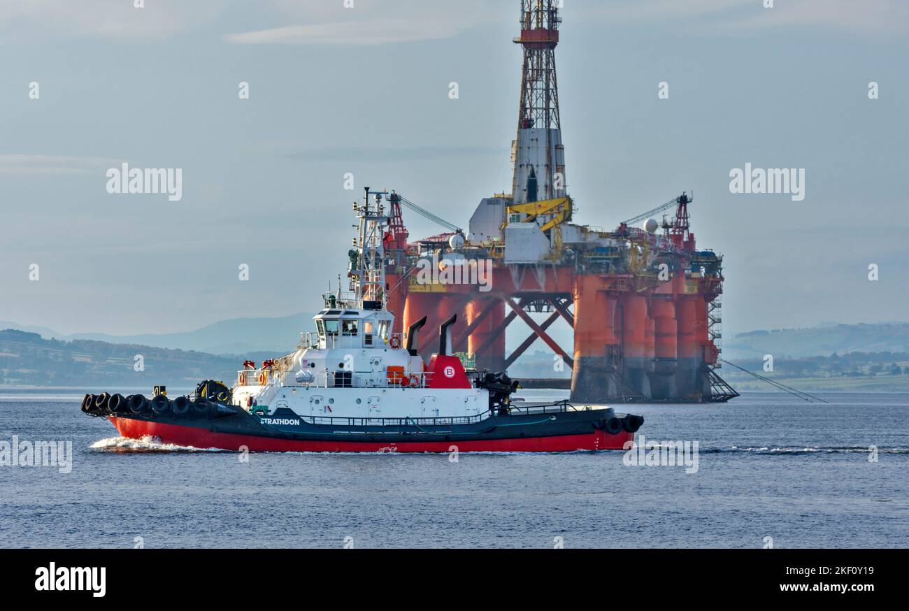 Cromarty Firth Scotland tug boat Strathdon passing in front of orange oil rig Transocean Leader Stock Photo
