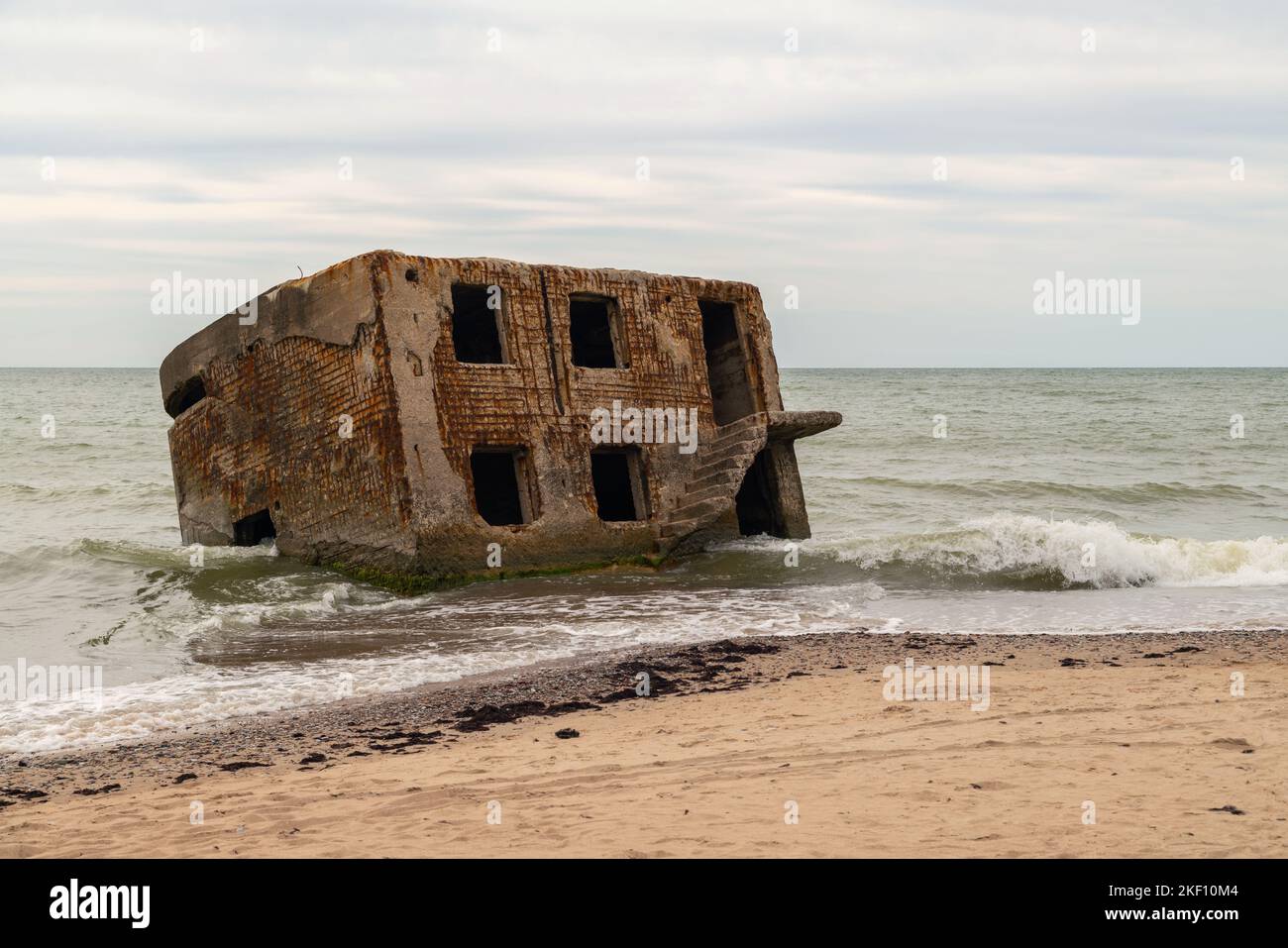 Abandoned buildings on the seashore in the water. War ruins decomposing ...