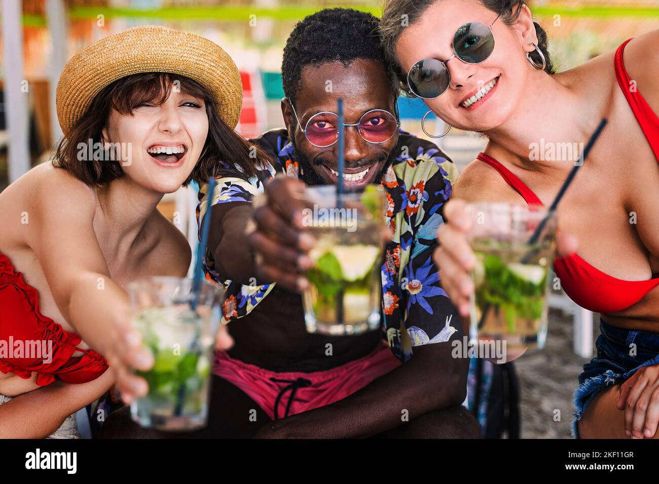 Joyful multi-ethnic young adult friends cheering looking at camera ...