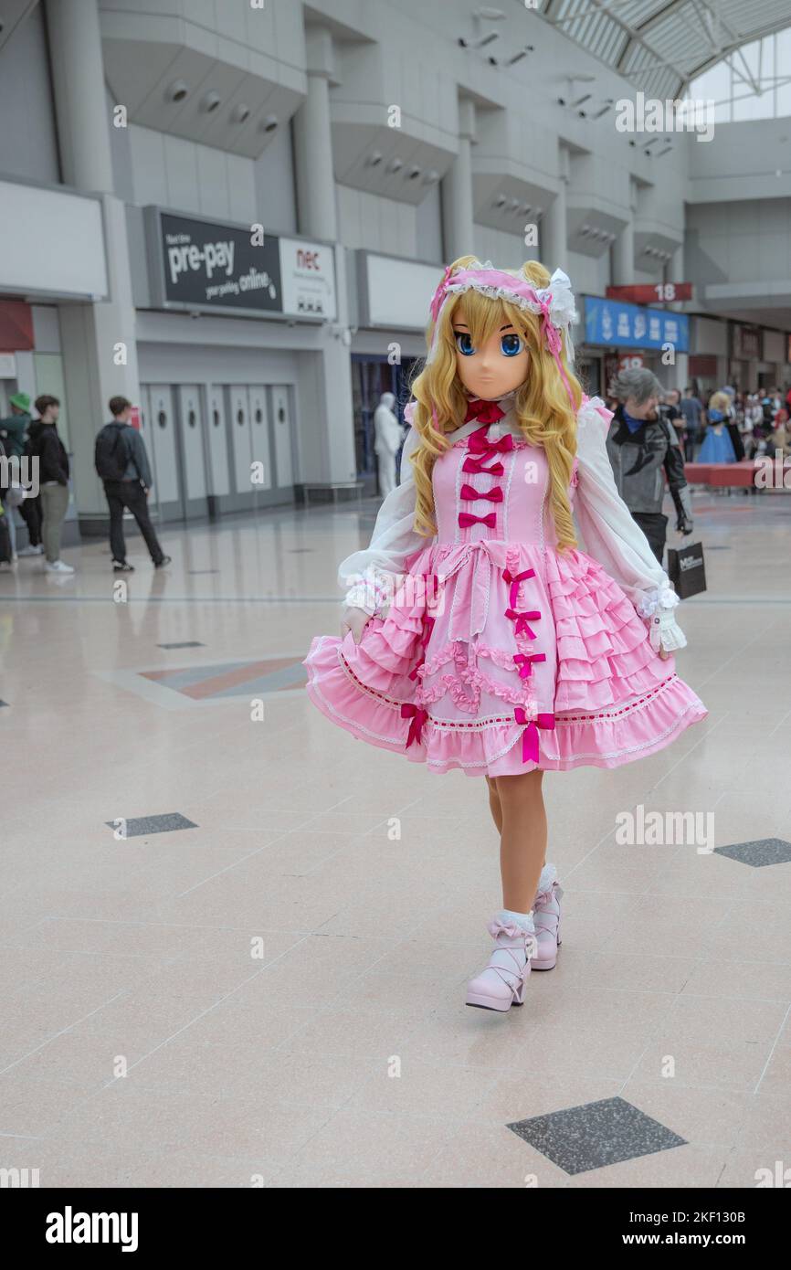 BIRMINGHAM NEC, UK - NOVEMBER 13, 2022.  A female cosplayer dressed as a popular Korean or japanese Anime Lycoris character with face mask at a UK com Stock Photo