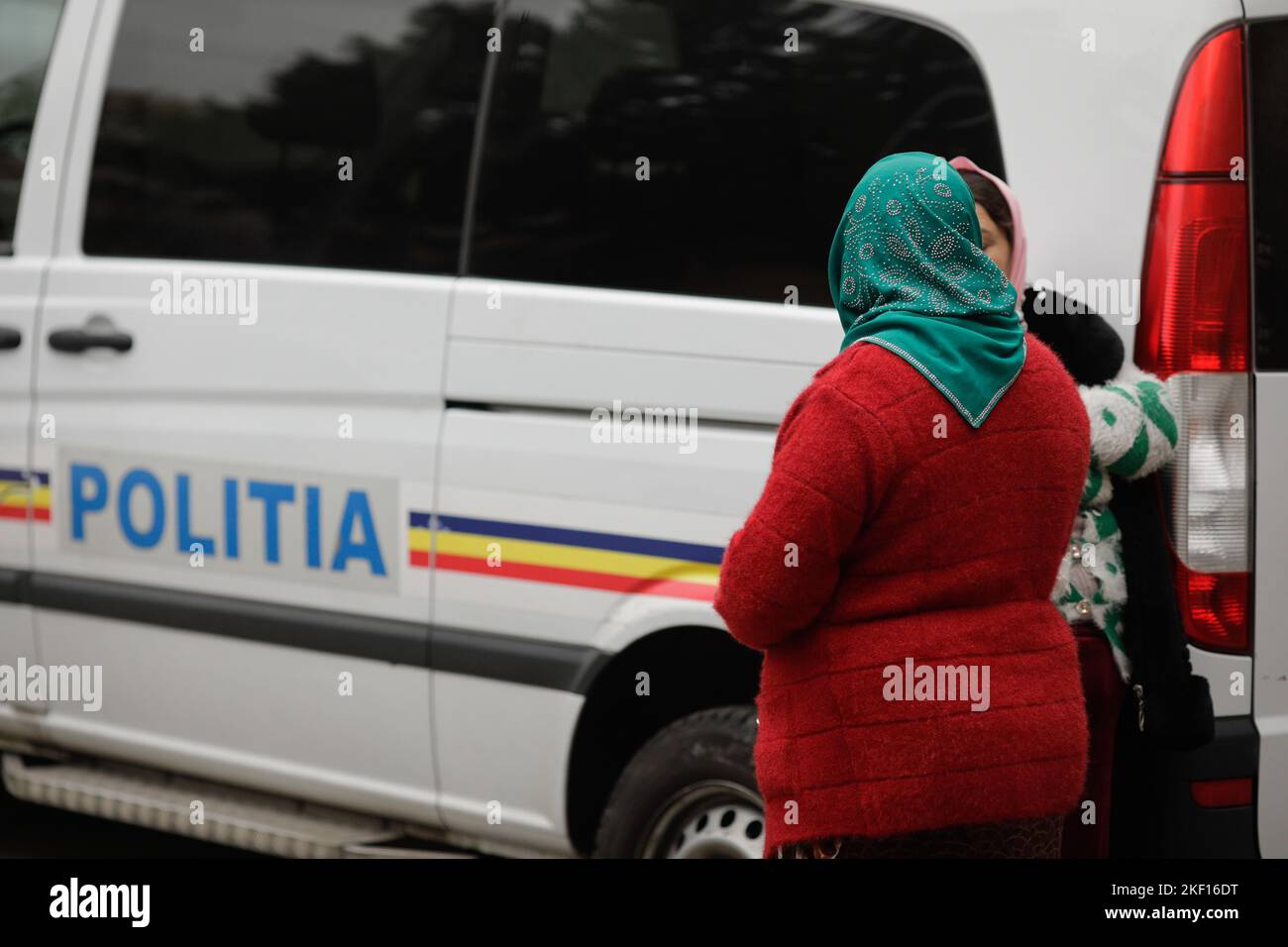 Bucharest, Romania - November 15, 2022: Two Roma women stand next to a Romanian Police van. Stock Photo