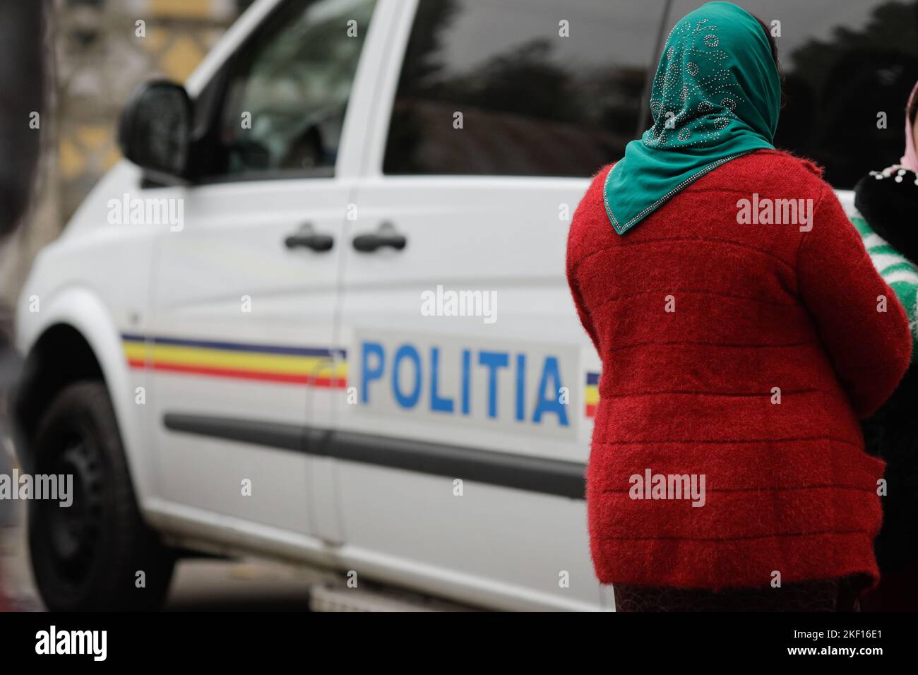 Bucharest, Romania - November 15, 2022: Two Roma women stand next to a Romanian Police van. Stock Photo