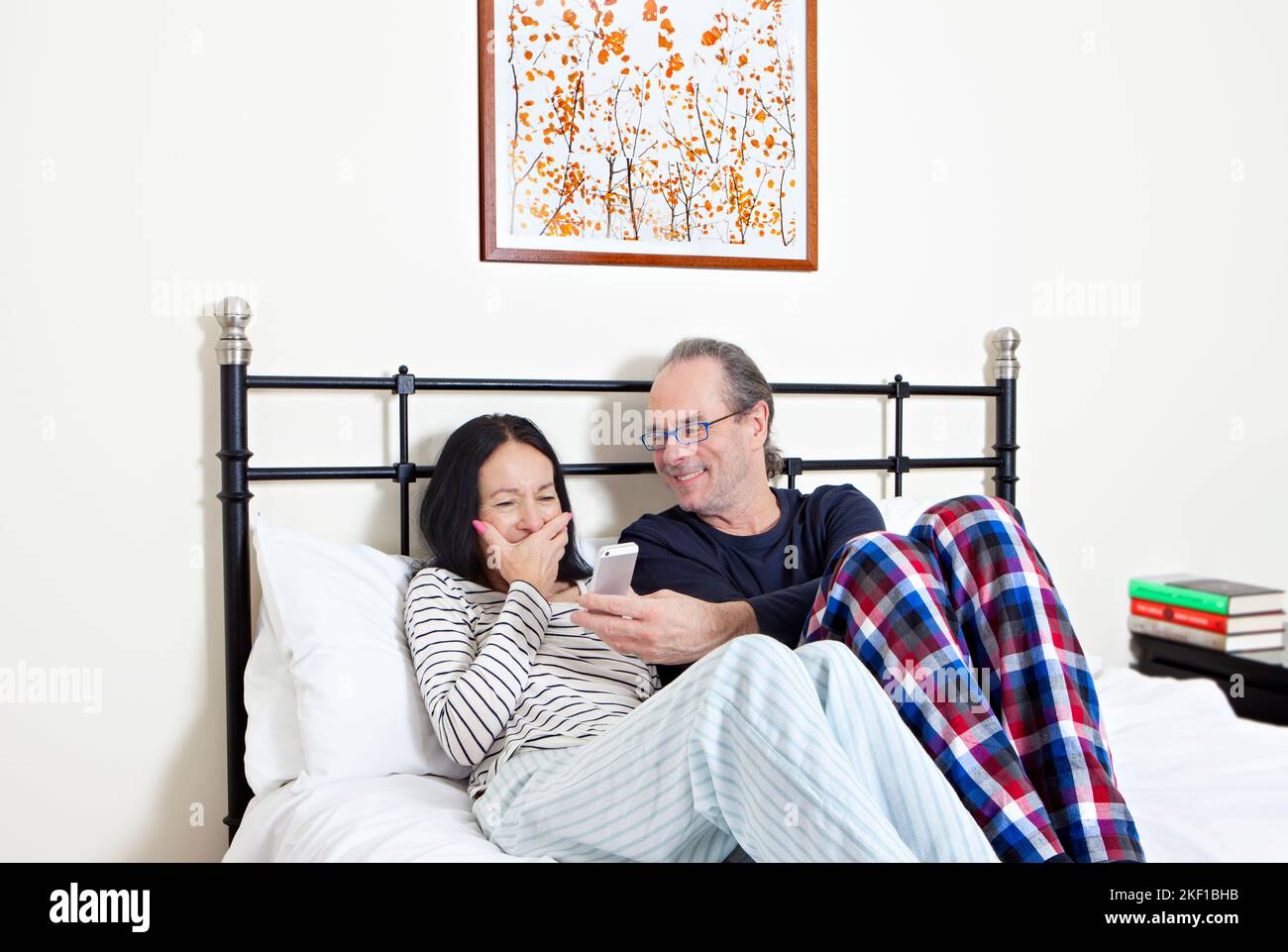 Mature couple in bed, laughing together Stock Photo