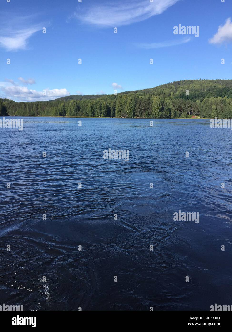a vertical shot of a scenic body of water surrounded by trees Stock ...