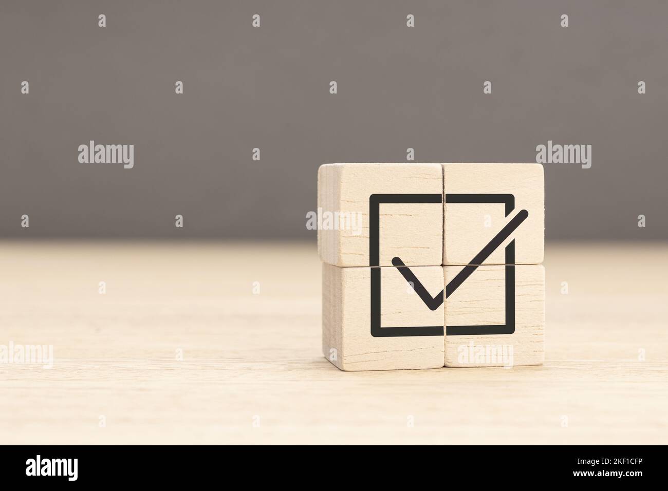 Corporate regulatory and compliance. Goals achievement and business success. Task completion. Wooden cube with check mark icon. Copy space Stock Photo