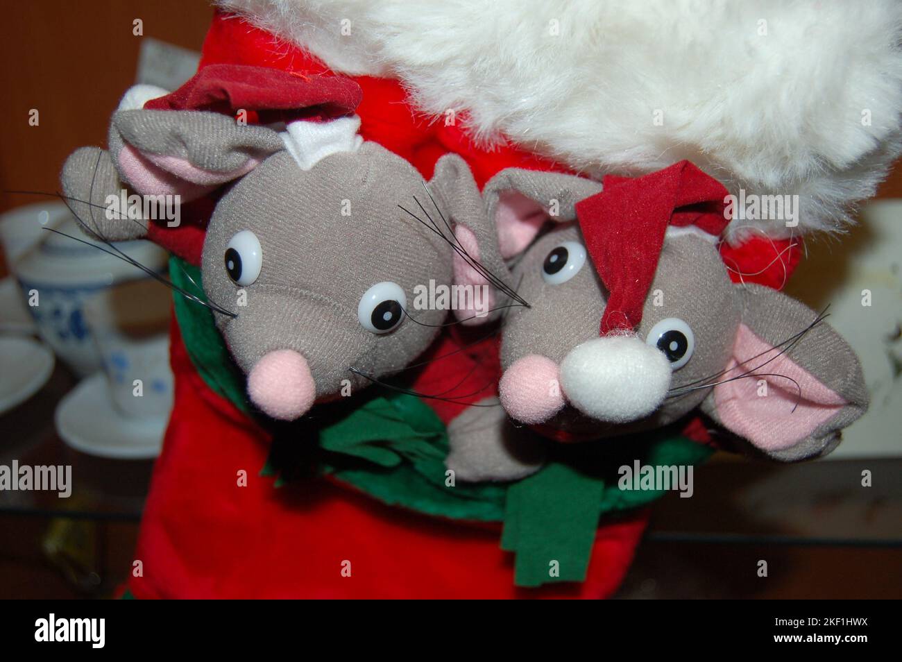 Two stuffed mice wearing a red Christmas hat with a white ball on the
