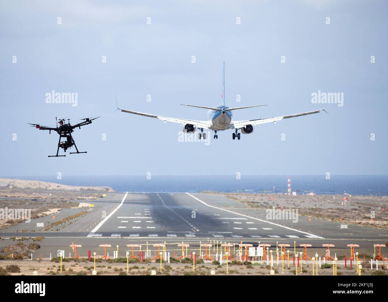 Drone near airport runway as aircraft, airplane lands. Stock Photo