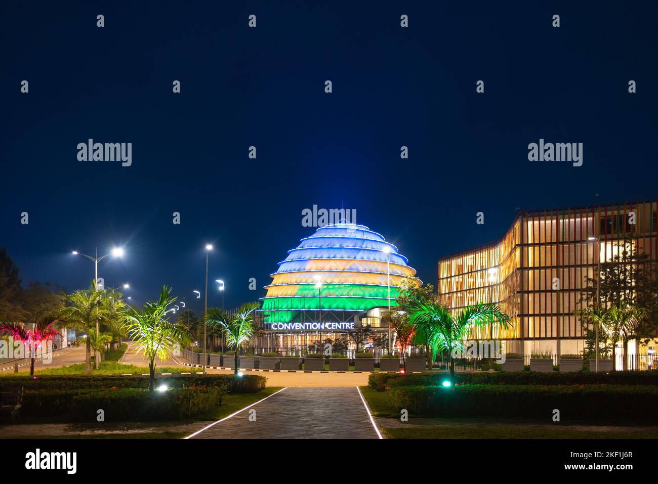 Kigali, Rwanda - August 19 2022: Kigali Convention Centre lit up in the colors of the Rwandan flag. The facility, designed after the inside of a king' Stock Photo