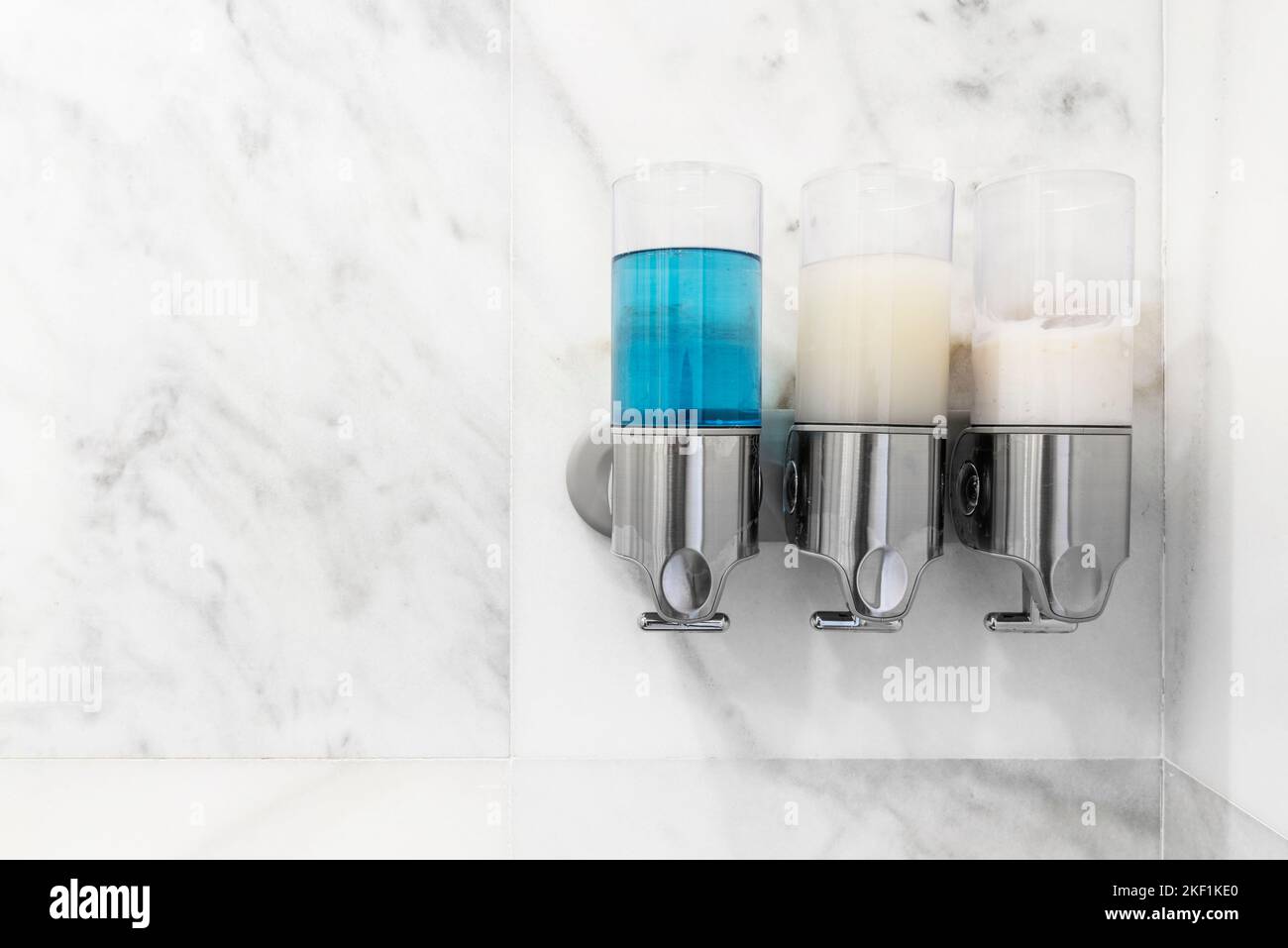 https://c8.alamy.com/comp/2KF1KE0/soap-shampoo-and-softener-dispensers-on-the-wall-of-a-shower-tiled-in-white-marble-2KF1KE0.jpg
