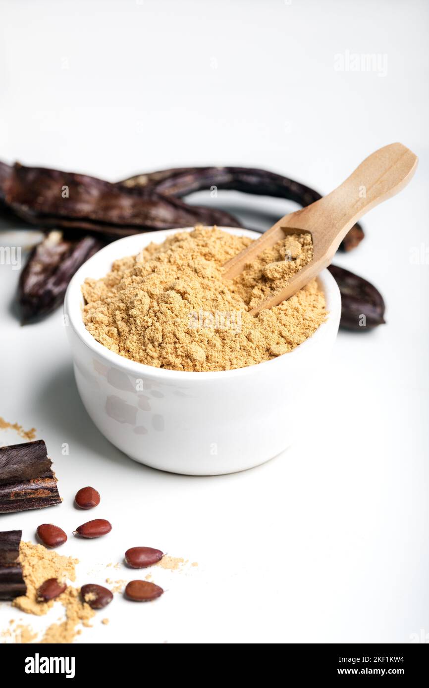 Carob pods and carob powder over white background Stock Photo Alamy