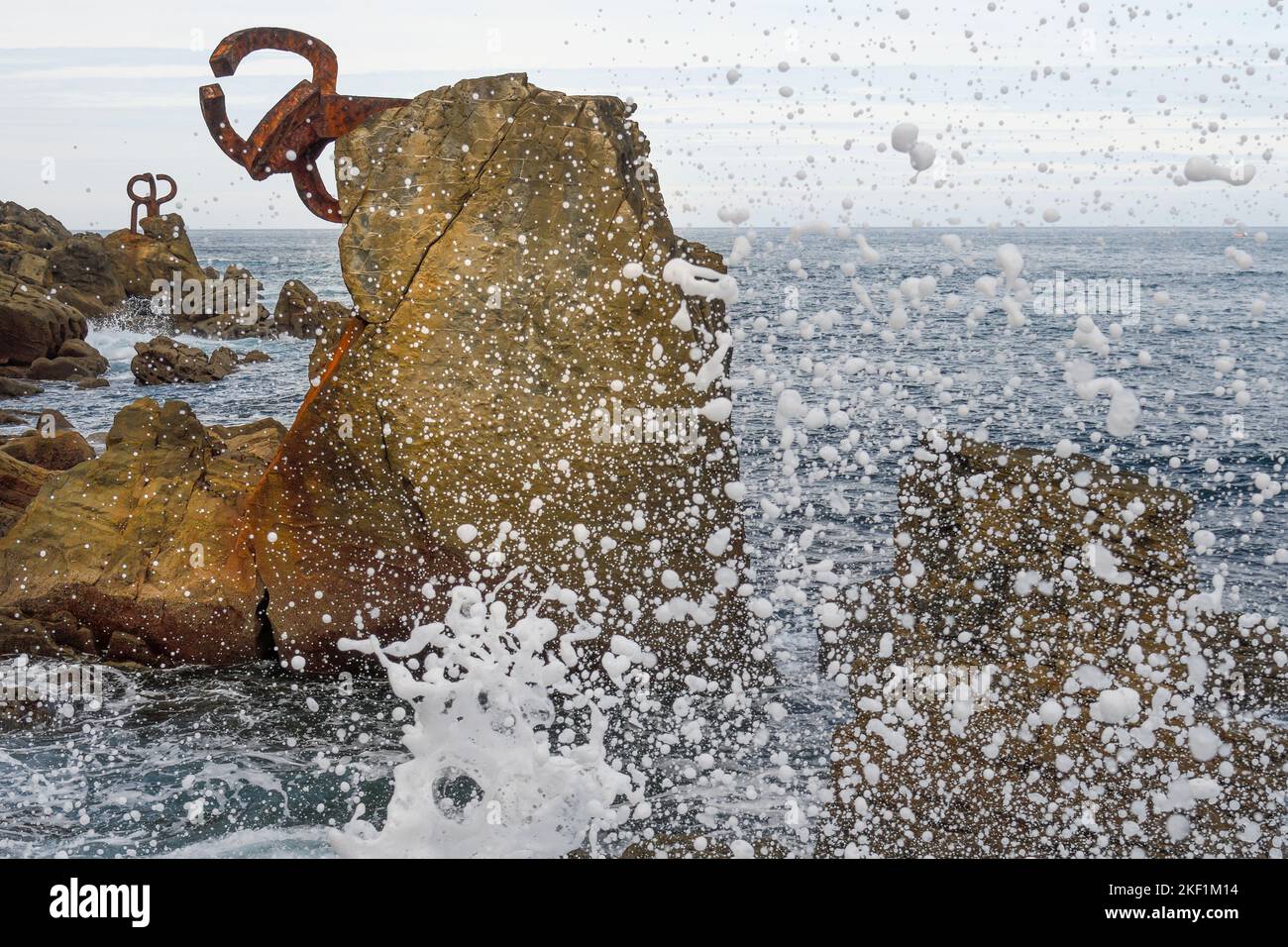 Sculpture of the Wind Comb in Donosti with the splashes of the waves in the foreground Stock Photo