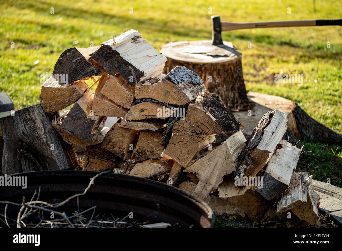 A split firewood with maul fire ring splitting wood Stock Photo