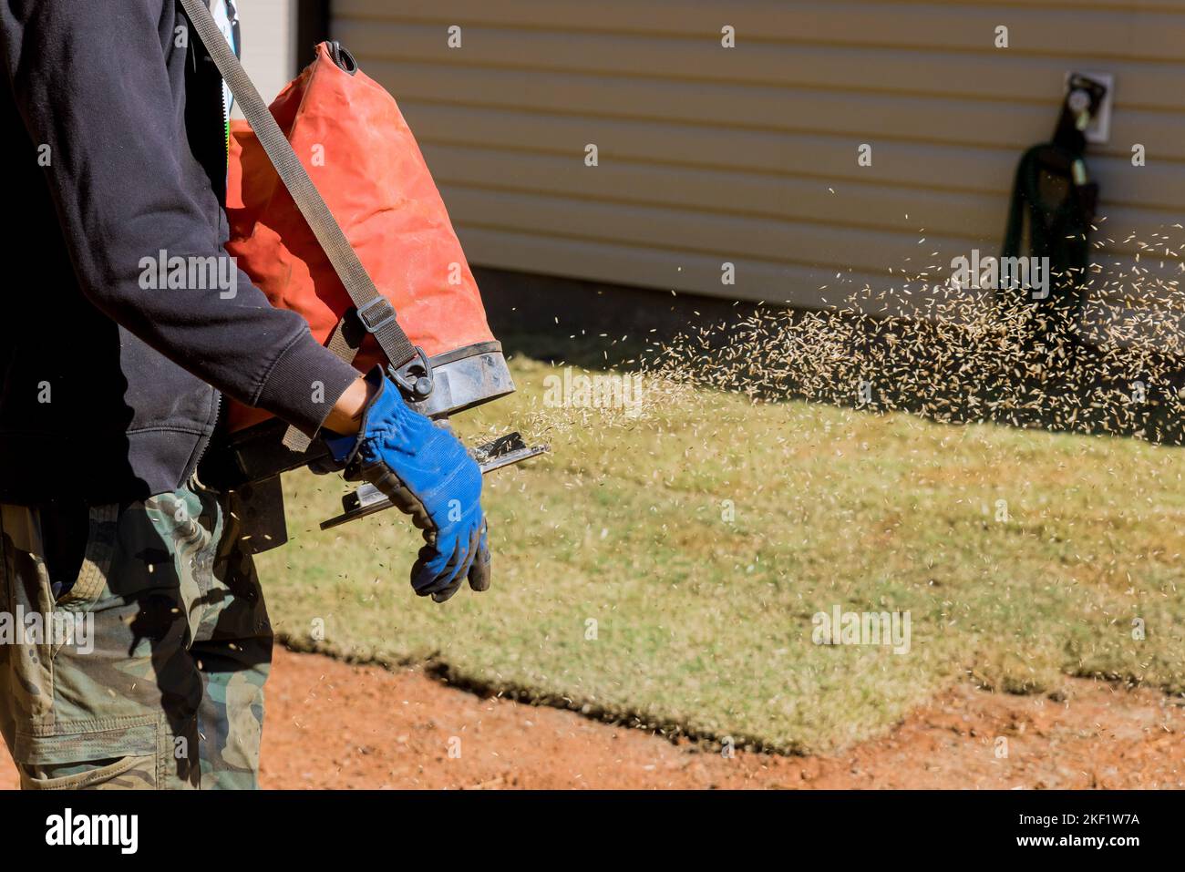 Using seeding device, landscapers work with gardeners to plant grass
