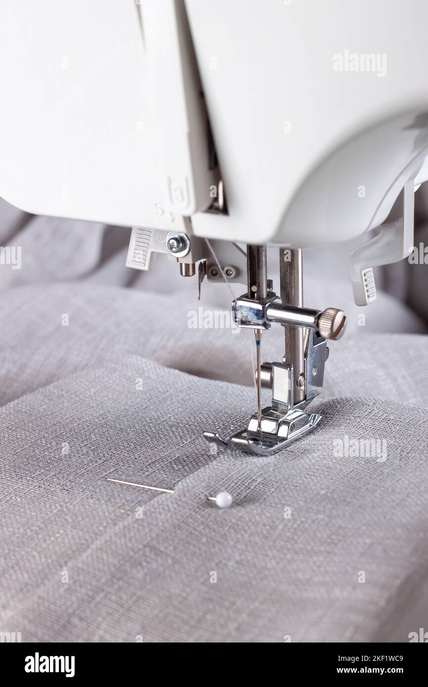 Modern sewing machine presser foot with linen fabric and thread ...