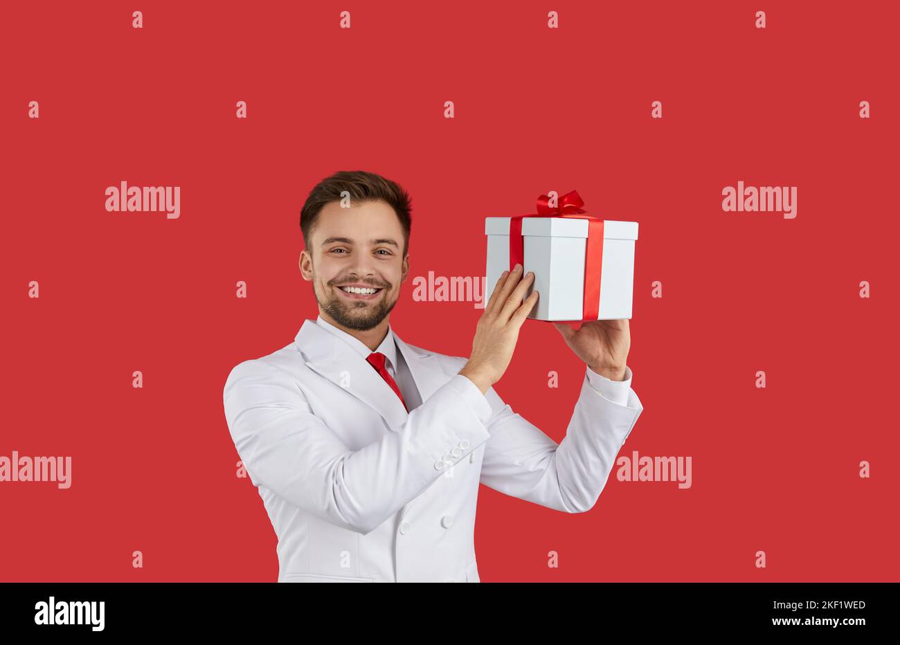 Smiling man in suit holding gift box Stock Photo