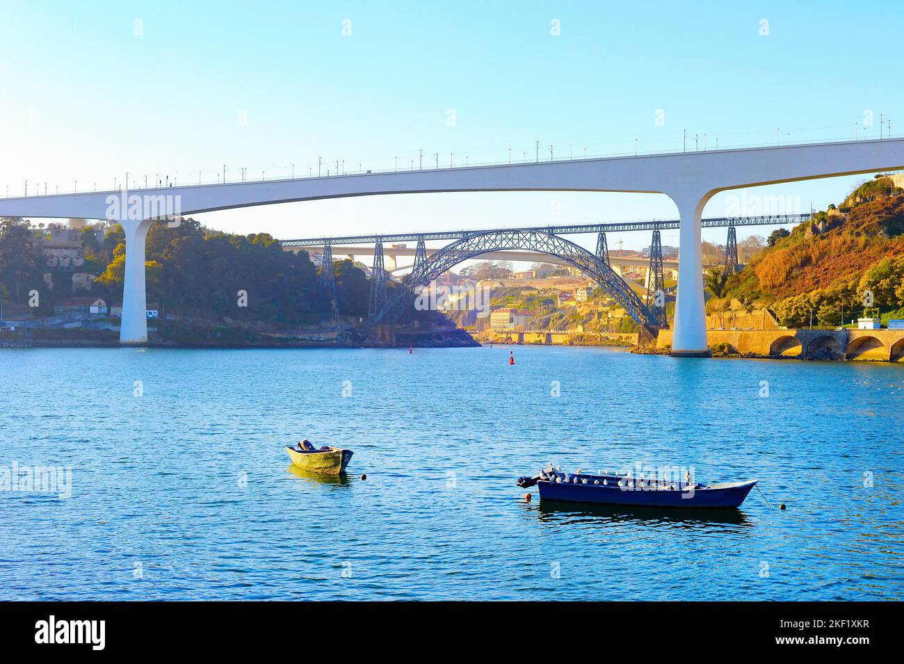 Railway bridges of Dona Maria Pia and Sao Joao, boats at Douro river, evening, Porto, Portugal Stock Photo