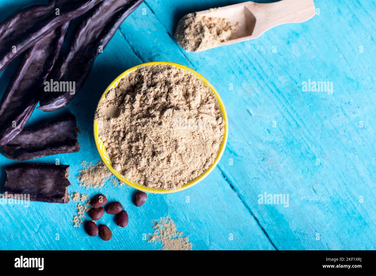 Carob pods and carob powder over a wooden background Stock Photo Alamy