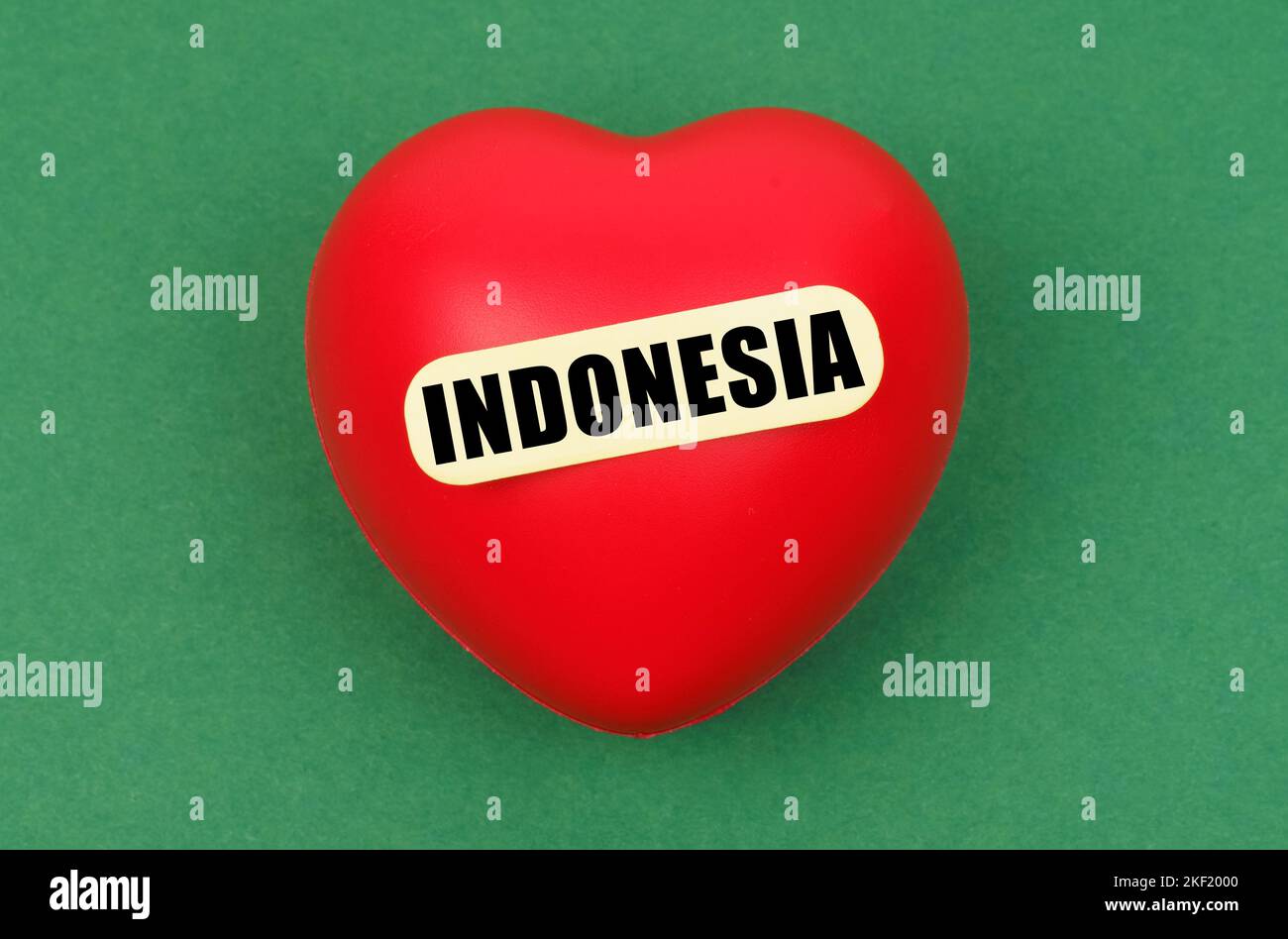 Love to motherland. On a green surface lies a red heart with the inscription - Indonesia Stock Photo