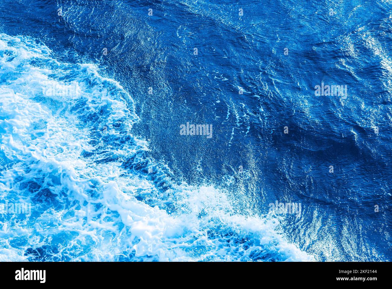 Aerial Ocean water blue surface with foam and waves. Stock Photo