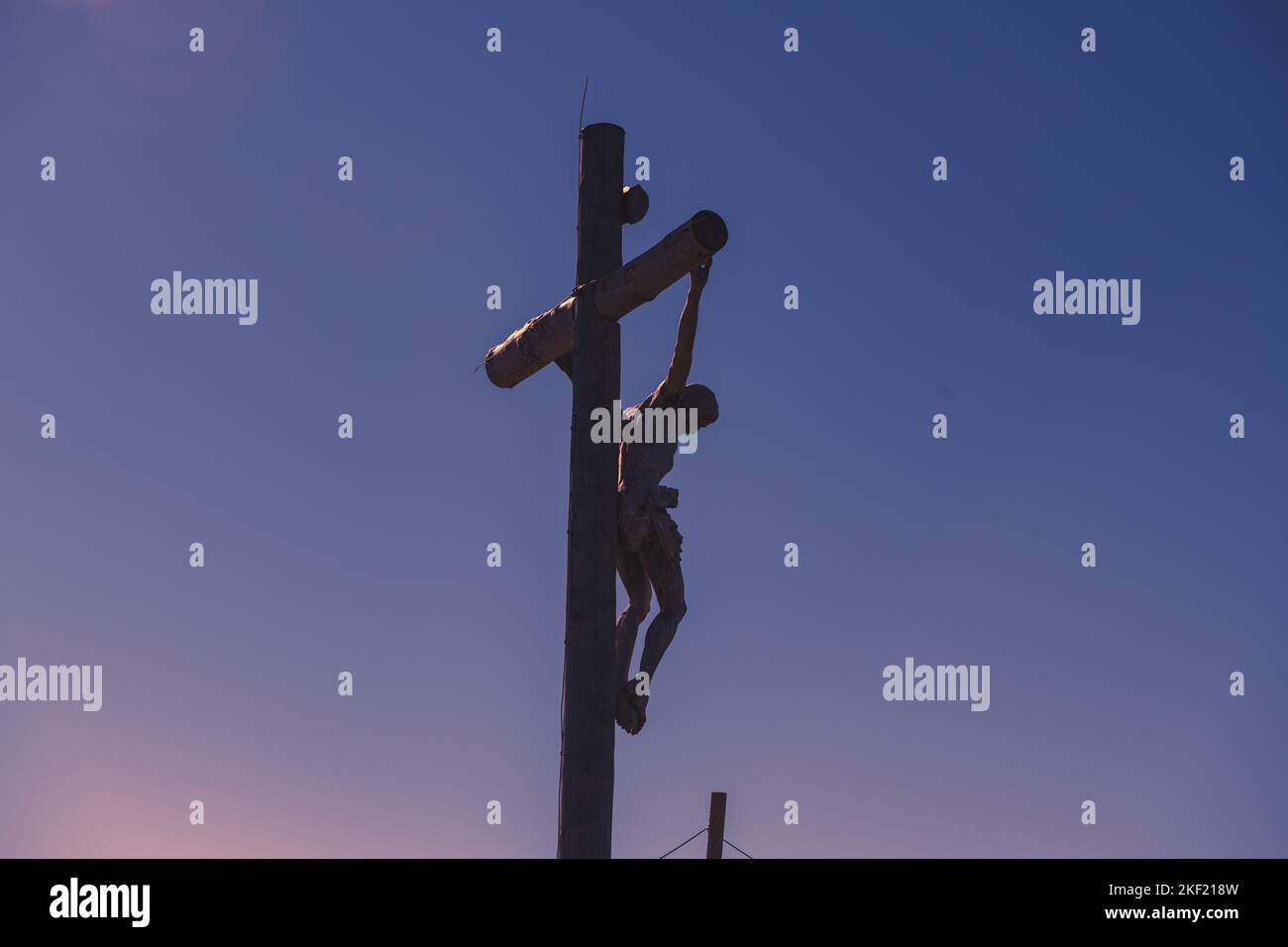 A statue of Jesus crucifixion against a blue sunset sky Stock Photo - Alamy