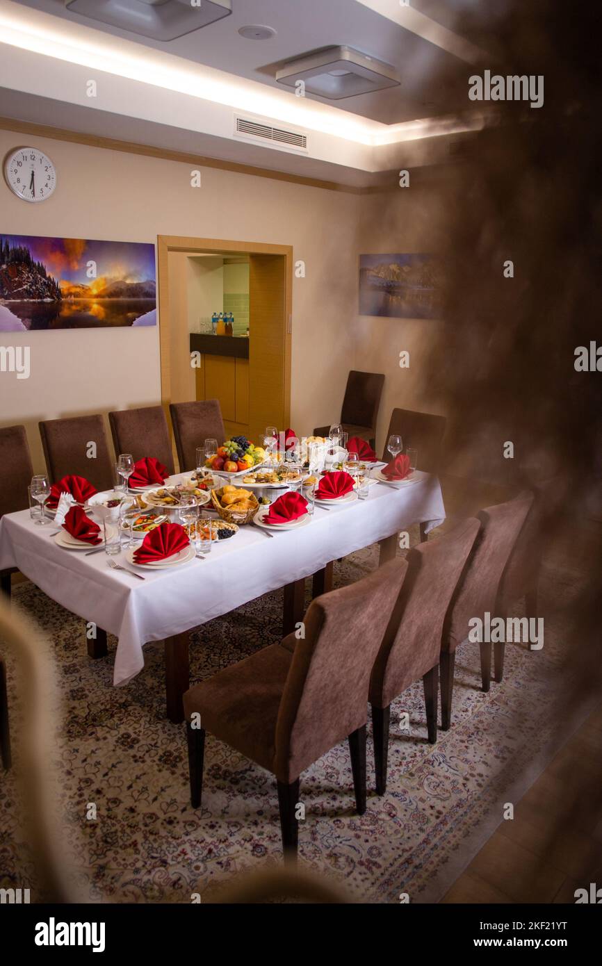 the table in the room is set in red tones with food for the holiday Stock Photo