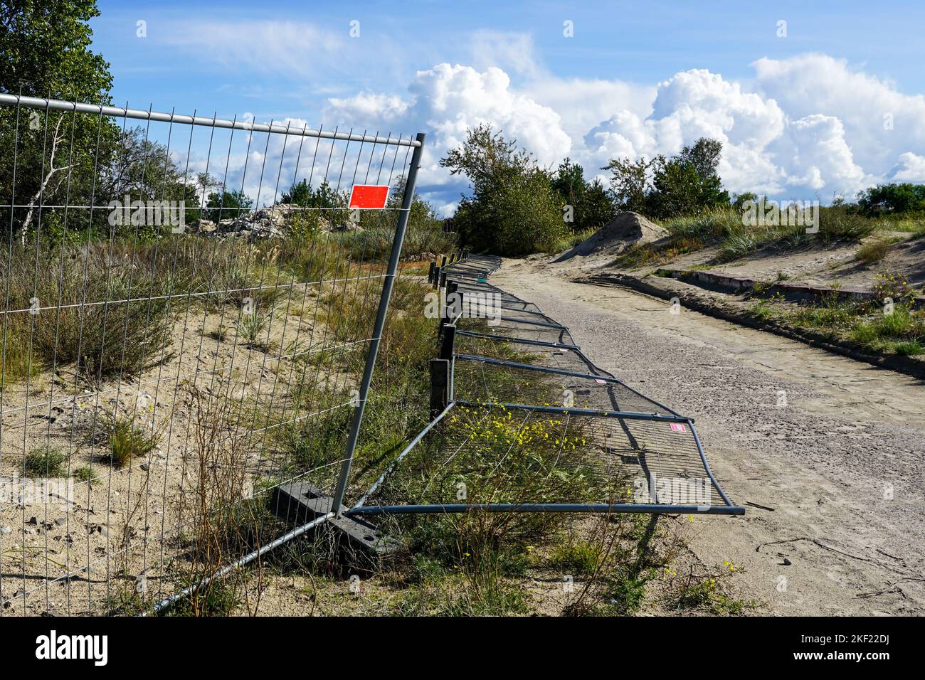 Partially overturned mobile steel fence with concrete base blocks with ...