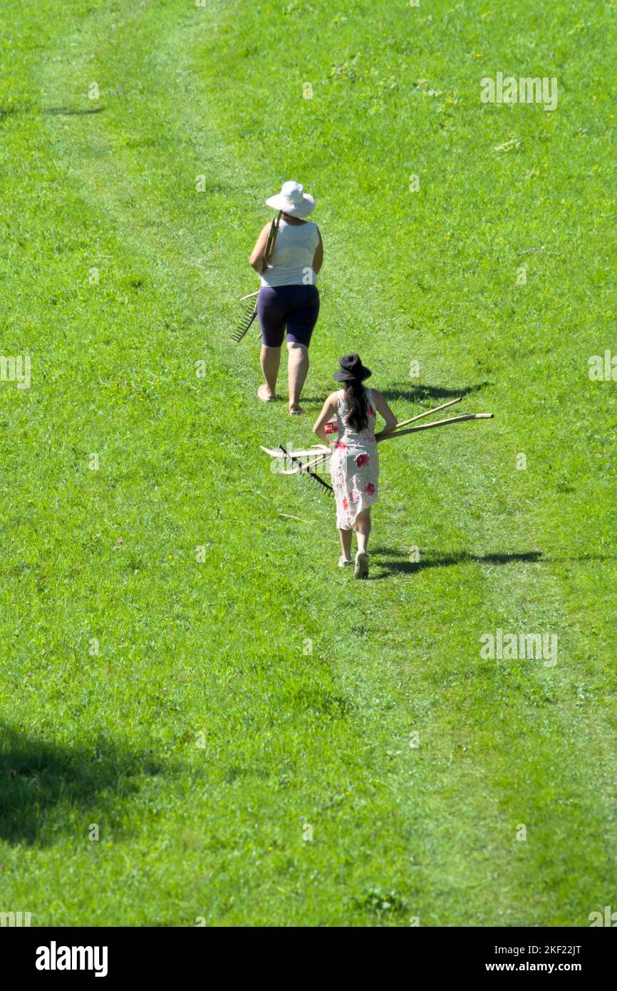 mother and daughter in field carrying farm tools Stock Photo Alamy